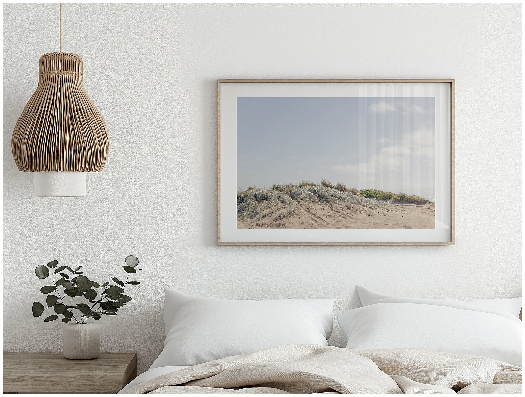 Large landscape artwork of coastal sand dunes with wispy grey-green grass hanging above a master bedroom bed, creating a calm and serene space.