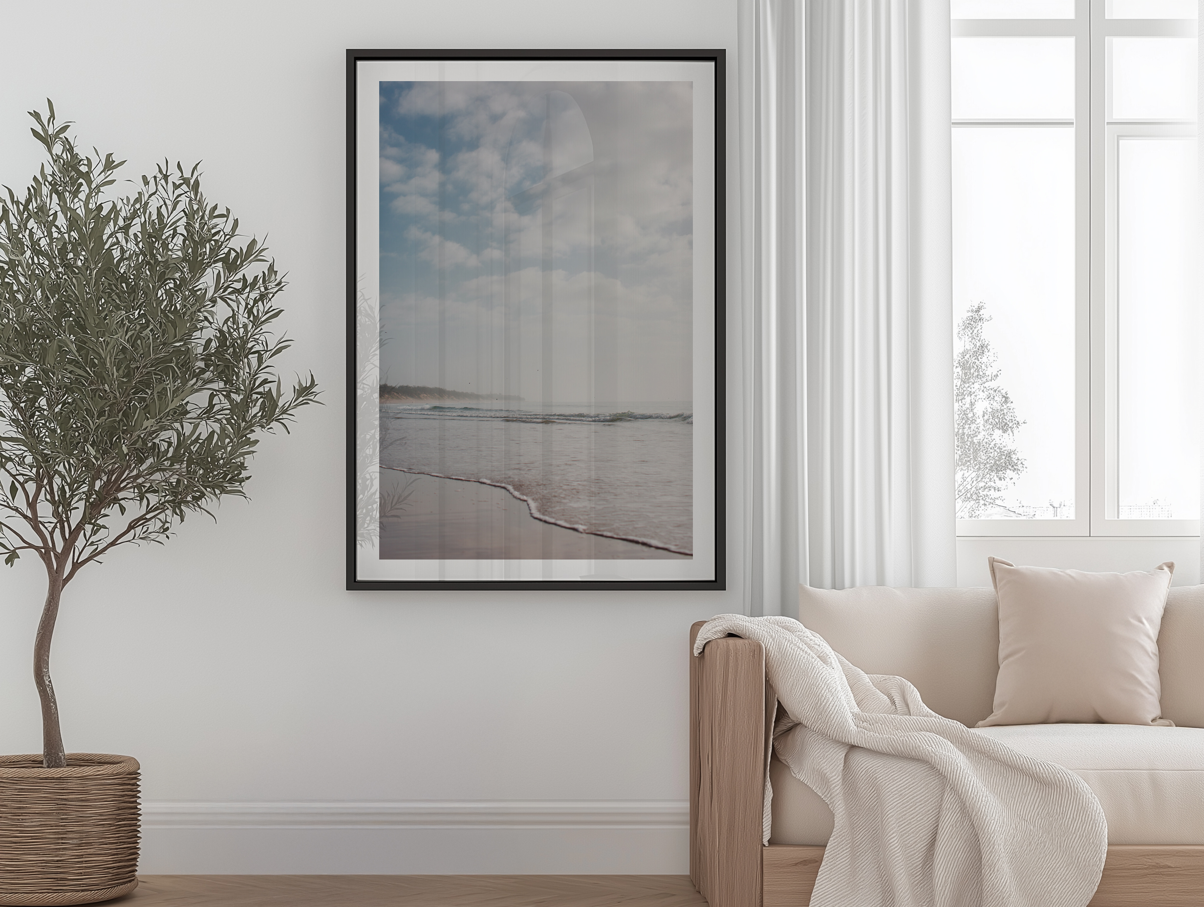 Black framed wall art in a relaxed hotel living space with soft furnishings.